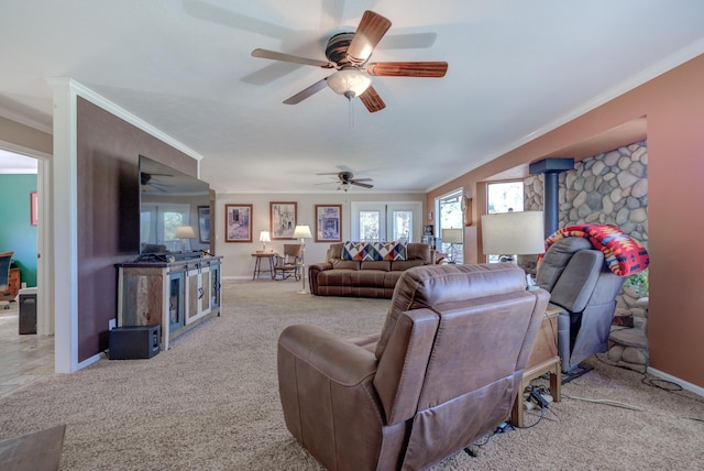 living room with a wood stove, light carpet, crown molding, and baseboards