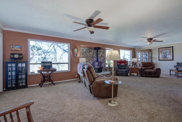 carpeted living room with a wood stove, a healthy amount of sunlight, crown molding, and baseboards