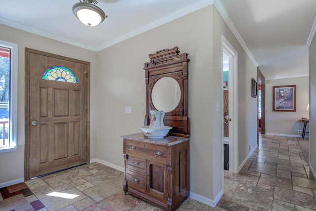 entryway featuring crown molding, stone tile flooring, and baseboards