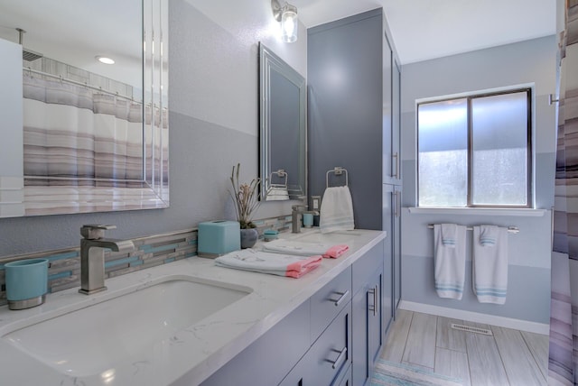 full bath with double vanity, curtained shower, visible vents, a sink, and baseboards