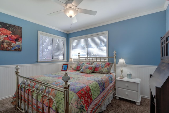 bedroom with ornamental molding, dark colored carpet, wainscoting, and ceiling fan