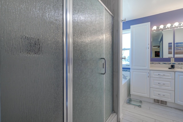 full bathroom with a shower stall and vanity