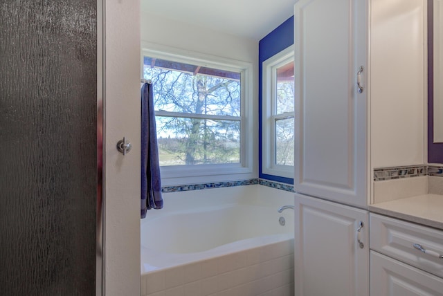 bathroom with a garden tub and vanity