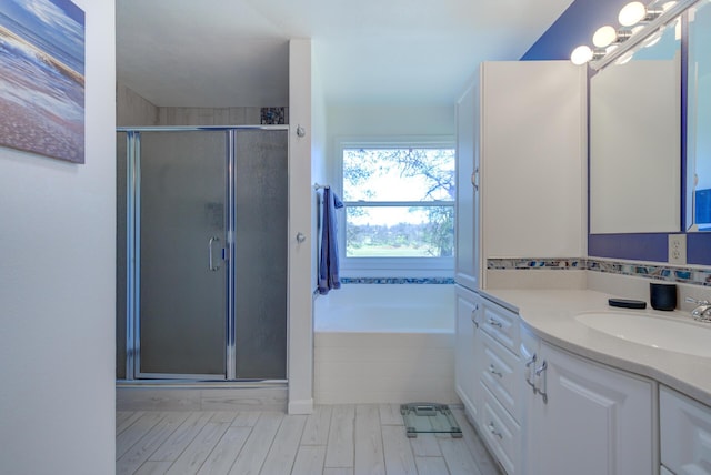 full bath with a stall shower, a garden tub, and vanity