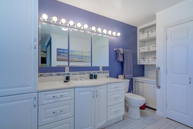 bathroom with toilet, wood finished floors, and vanity