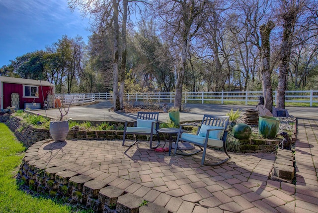 view of patio / terrace with an outdoor structure and fence