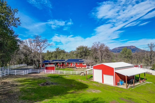 view of yard featuring an outbuilding, a mountain view, driveway, and a detached garage