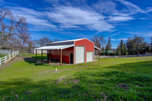 view of pole building featuring a rural view, a yard, and fence