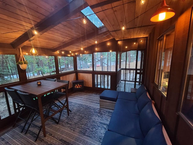 sunroom featuring wood ceiling, beam ceiling, and a skylight