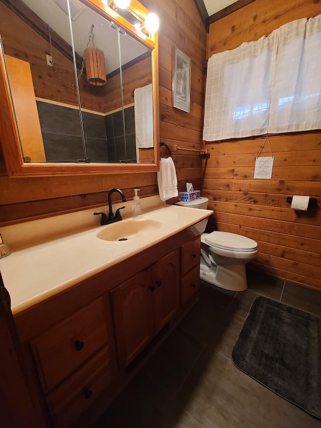 bathroom featuring toilet, wooden walls, vanity, and tile patterned floors