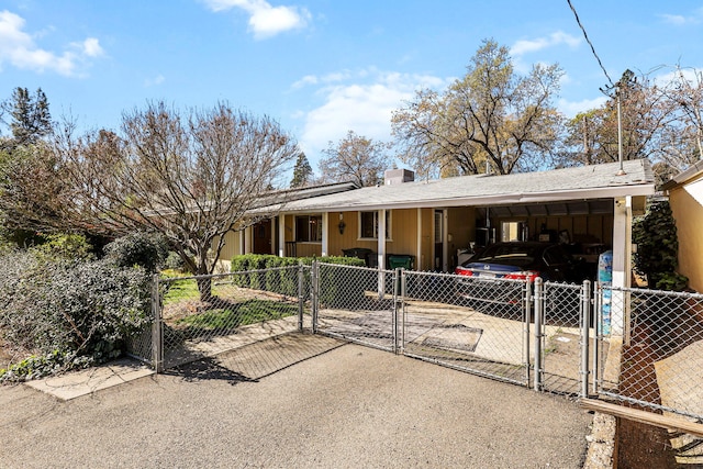 single story home with a carport, a gate, fence, and concrete driveway