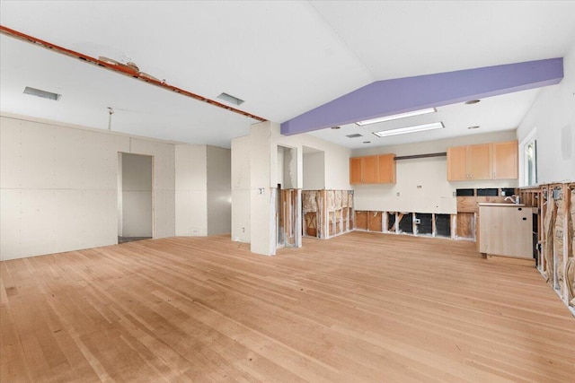 unfurnished living room with light wood-type flooring and lofted ceiling