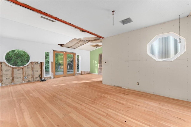 unfurnished living room with french doors, visible vents, and light wood-style floors