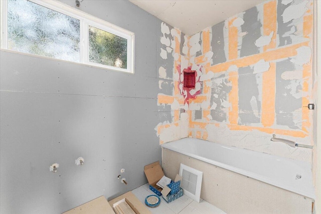 bathroom featuring tile patterned floors, visible vents, and a bathing tub