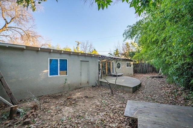 back of house featuring a patio area, fence, and stucco siding