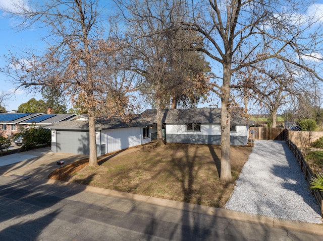 single story home with an attached garage, fence, a front lawn, and concrete driveway