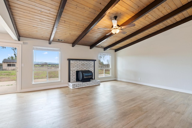 unfurnished living room featuring light wood-style flooring, plenty of natural light, lofted ceiling with beams, and baseboards