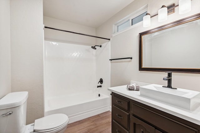 bathroom featuring bathing tub / shower combination, vanity, toilet, and wood finished floors