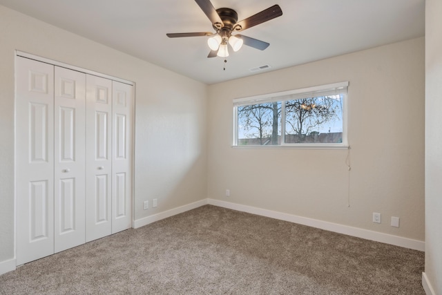 unfurnished bedroom featuring carpet floors, baseboards, visible vents, and a closet