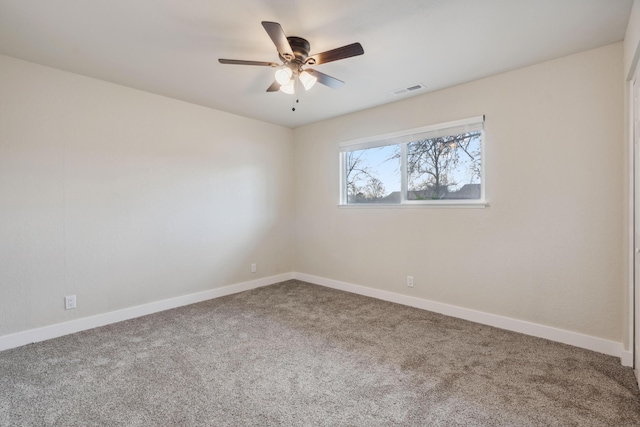 empty room with carpet, visible vents, ceiling fan, and baseboards