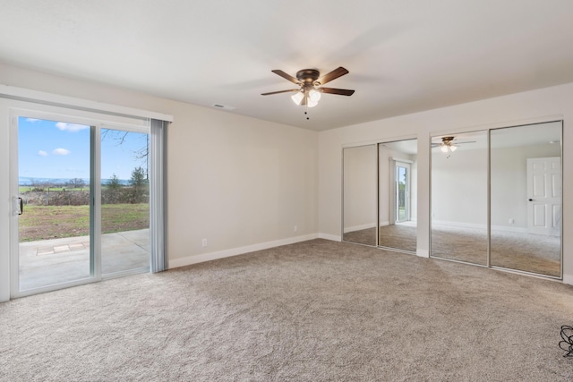 unfurnished bedroom featuring baseboards, visible vents, access to outside, carpet flooring, and multiple closets