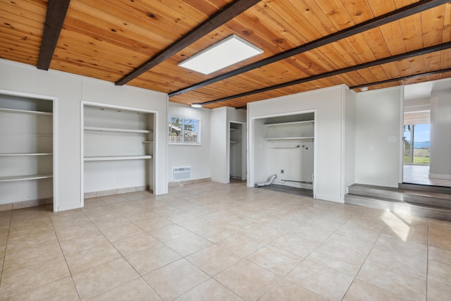 unfurnished bedroom with a skylight, light tile patterned floors, wood ceiling, beamed ceiling, and baseboards