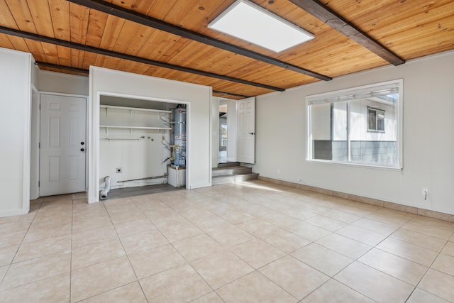 spare room featuring light tile patterned floors, beamed ceiling, and wood ceiling