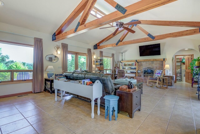 living area with a wealth of natural light, beam ceiling, and a fireplace