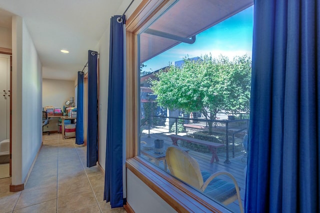 doorway to outside featuring baseboards and light tile patterned floors