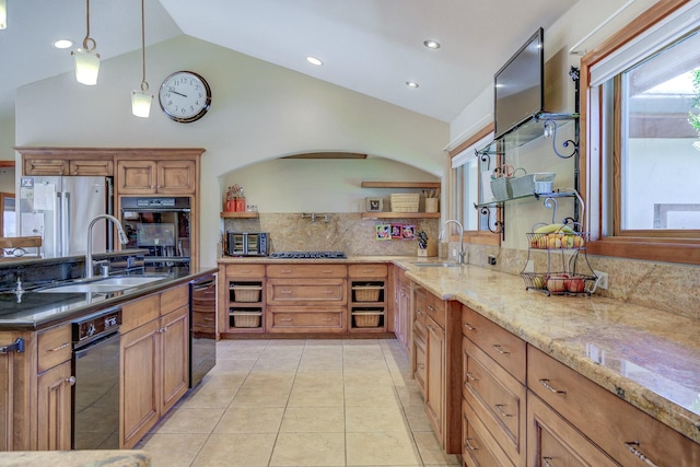 kitchen with brown cabinetry, black oven, a sink, and decorative light fixtures