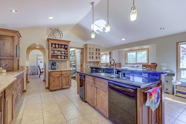 kitchen featuring decorative light fixtures, tasteful backsplash, glass insert cabinets, a sink, and dishwasher