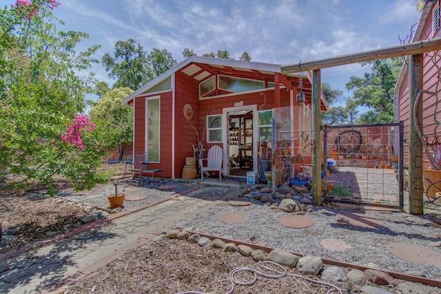 exterior space featuring a gate, fence, and an outbuilding