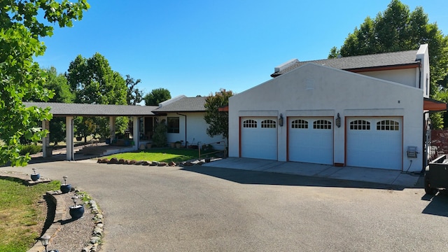 view of front of home with an attached garage, aphalt driveway, and stucco siding