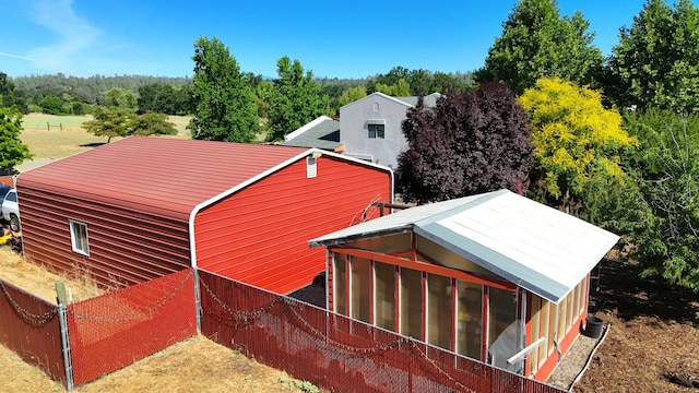 view of side of property with fence and a sunroom