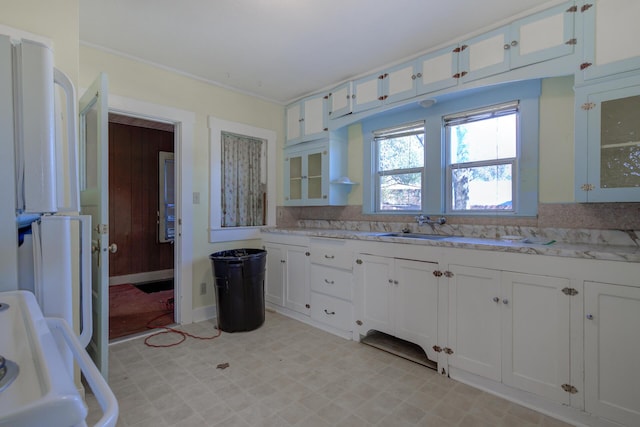 kitchen with a sink, white cabinets, light countertops, range, and light floors