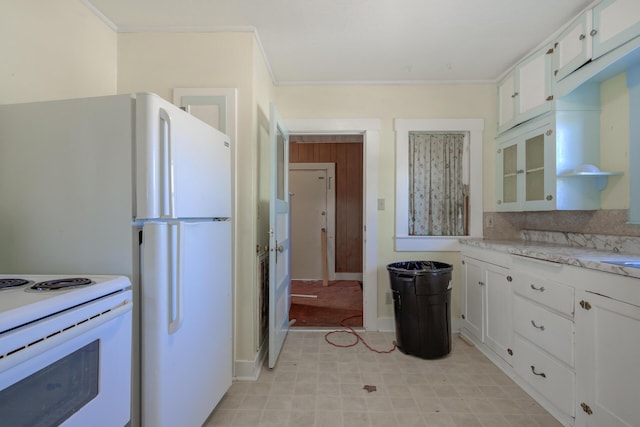 kitchen featuring glass insert cabinets, light countertops, white cabinetry, and crown molding