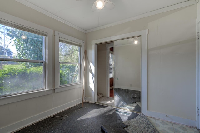 spare room with ornamental molding, a ceiling fan, and baseboards