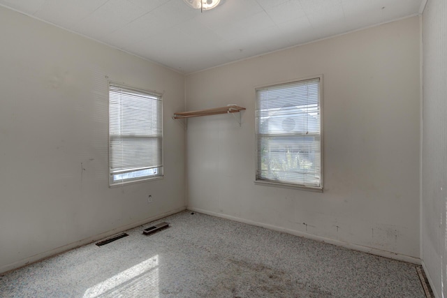 unfurnished room with visible vents