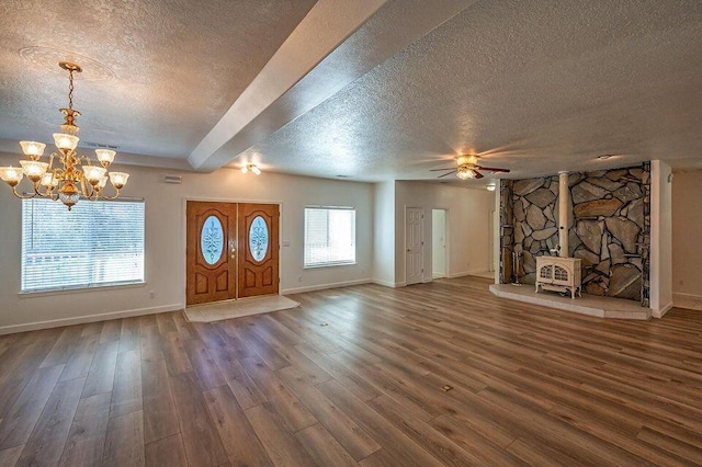 entryway featuring a textured ceiling, dark wood-style flooring, a wood stove, and baseboards