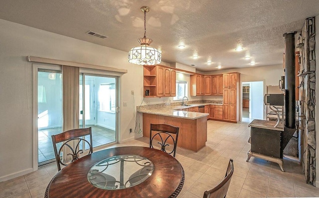 kitchen with visible vents, a peninsula, light countertops, open shelves, and a sink