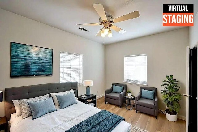 bedroom with light wood-style floors, visible vents, baseboards, and a ceiling fan