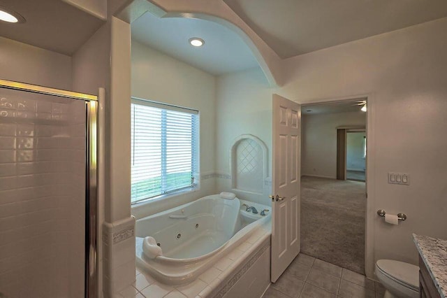 full bath with toilet, vanity, tile patterned floors, a tub with jets, and a stall shower