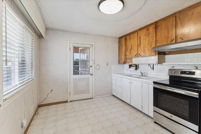 kitchen with light countertops, stainless steel electric range oven, under cabinet range hood, and light floors