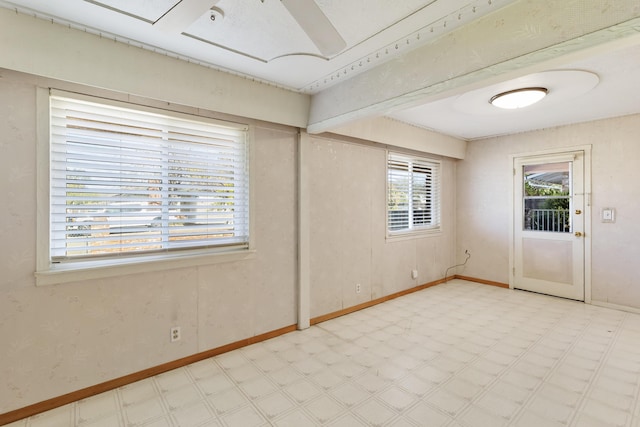 spare room featuring baseboards and light floors