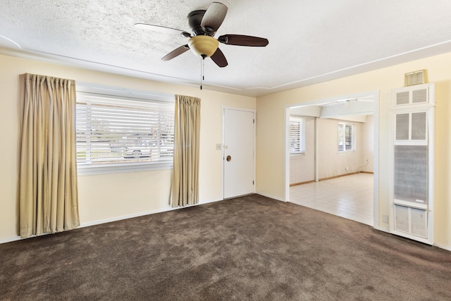 empty room with carpet floors, ceiling fan, and a textured ceiling