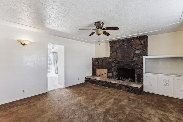 unfurnished living room with dark carpet, a fireplace, a textured ceiling, and a ceiling fan