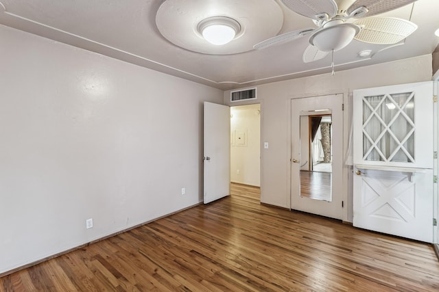 unfurnished bedroom with a ceiling fan, visible vents, and wood finished floors