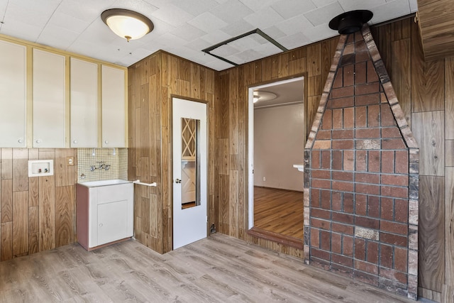 empty room with wood walls and light wood-style flooring