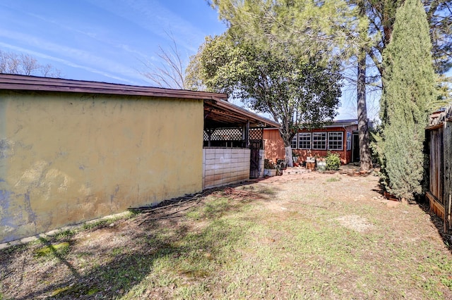 view of yard featuring fence and an outbuilding