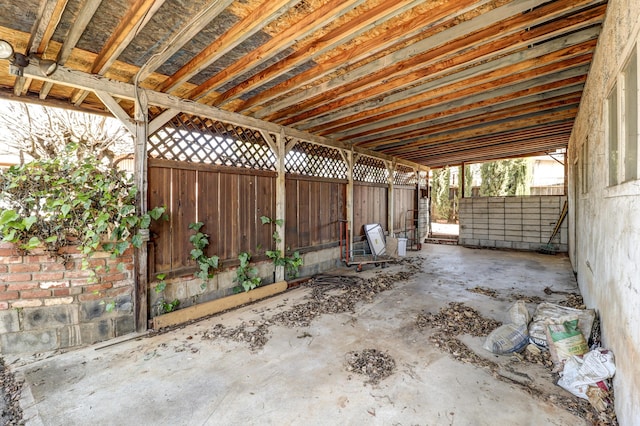 view of patio / terrace with a carport, an outdoor structure, and an exterior structure